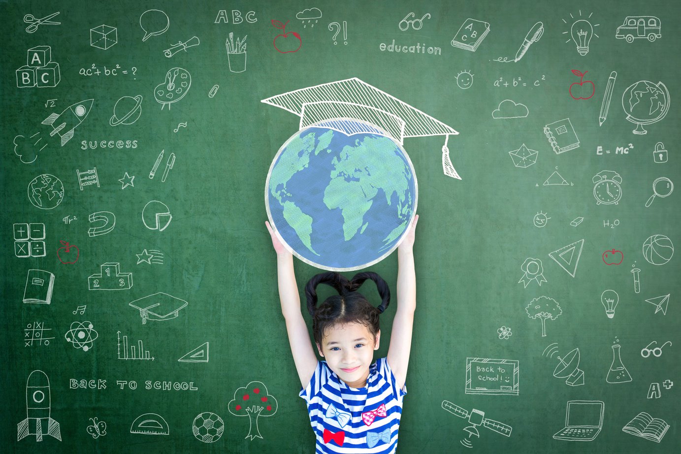 Educated school child girl lifting world globe doodle on chalkboard for children's education international children day and world literacy day concept