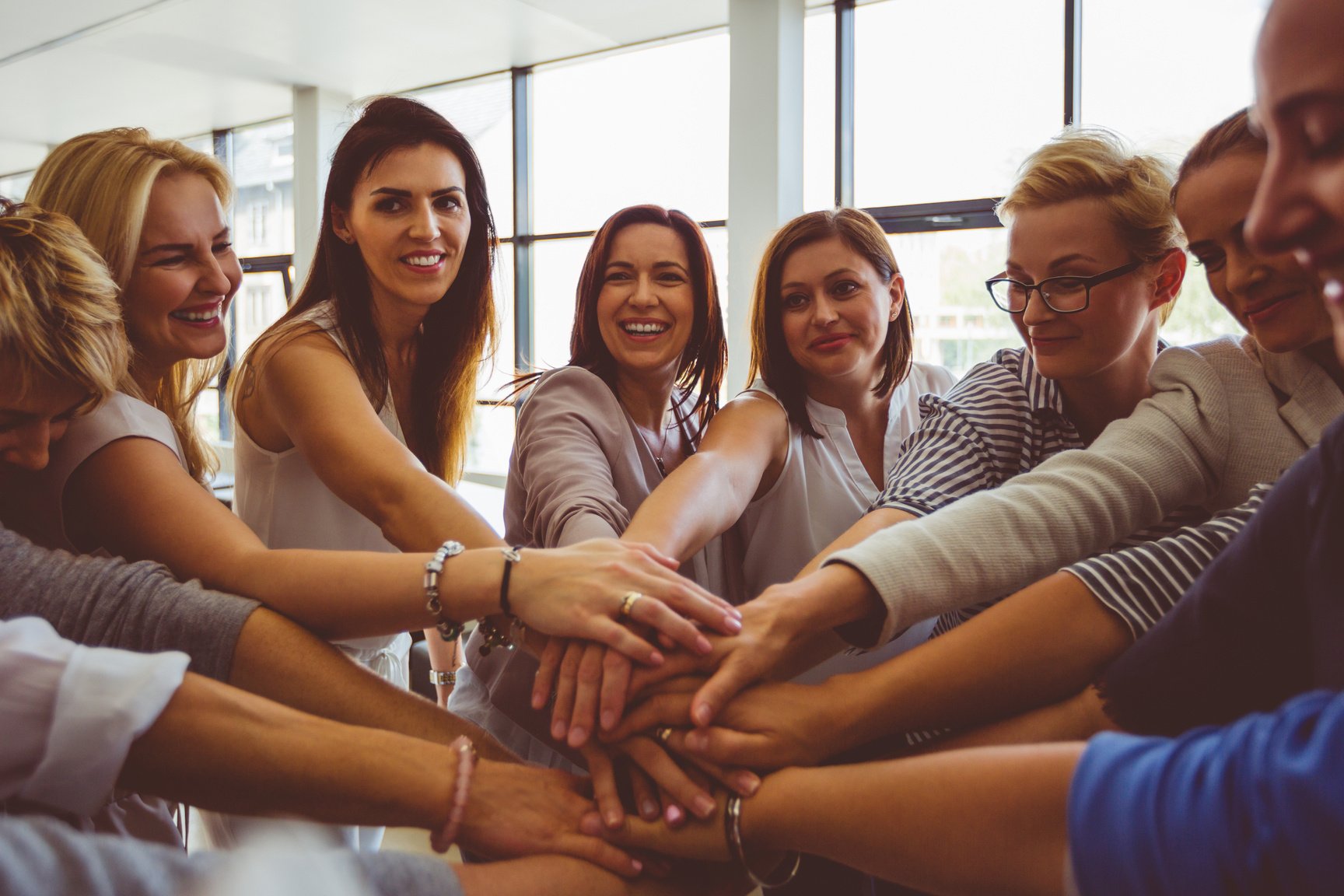 Women’s team. Group of happy women joining hands